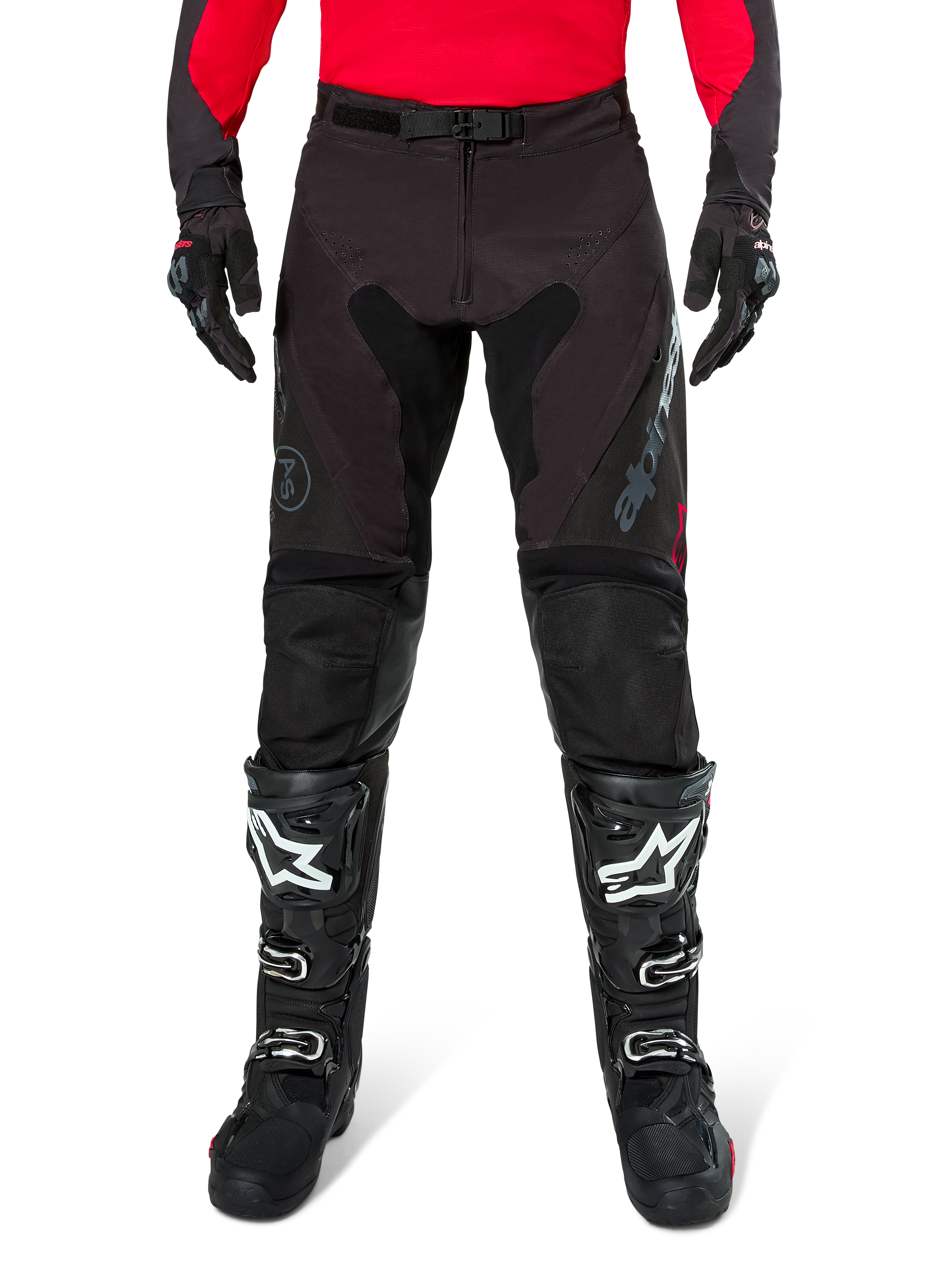Alpinestars Pro-Dura Pants, svarta och mörkgrå endurobyxor, bärs med en röd långärmad tröja och svarta motocross-stövlar, med grå Alpinestars-logotyp och slitstark ripstop-konstruktion för terrängkörning