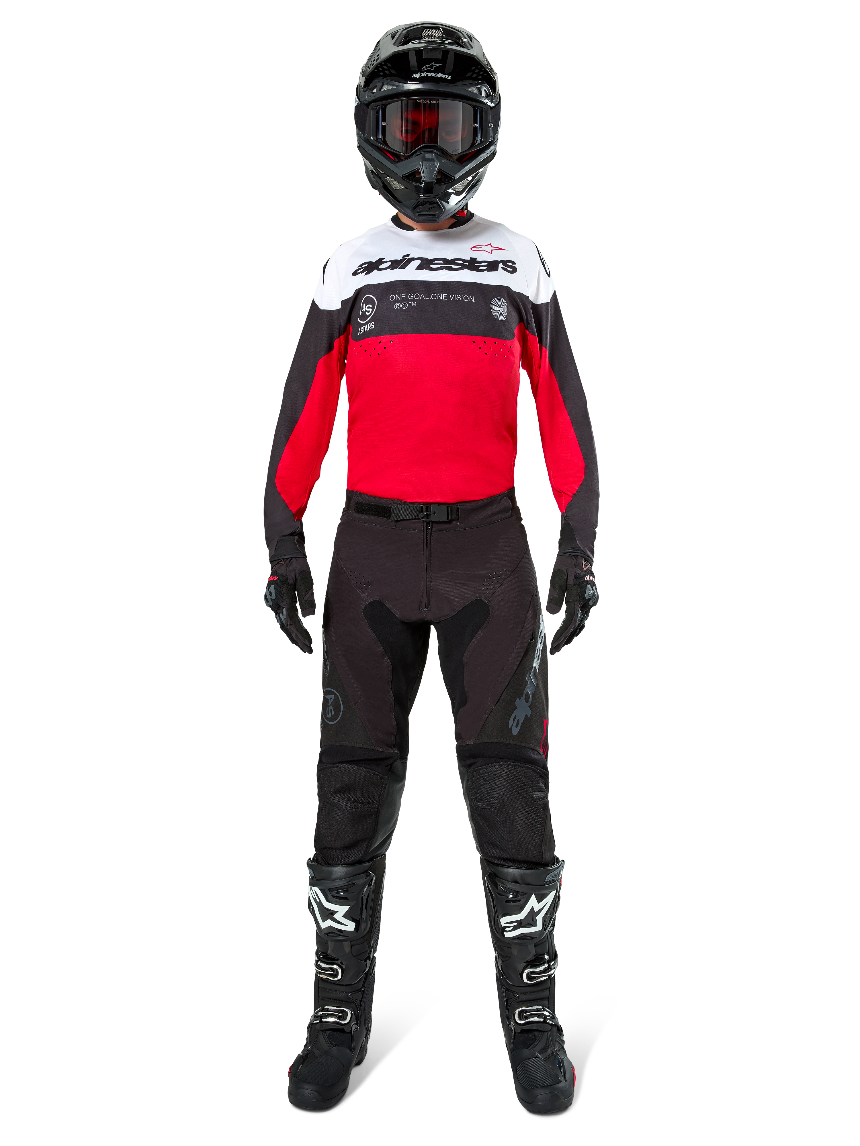 Motocrossförare iförd Alpinestars Pro-Dura-byxor i svart och Magnet, kombinerat med röd, vit och svart tröja, svart hjälm och svarta stövlar, komplett utrustning för terrängkörning, slitstark och lätt design för endurokörning
