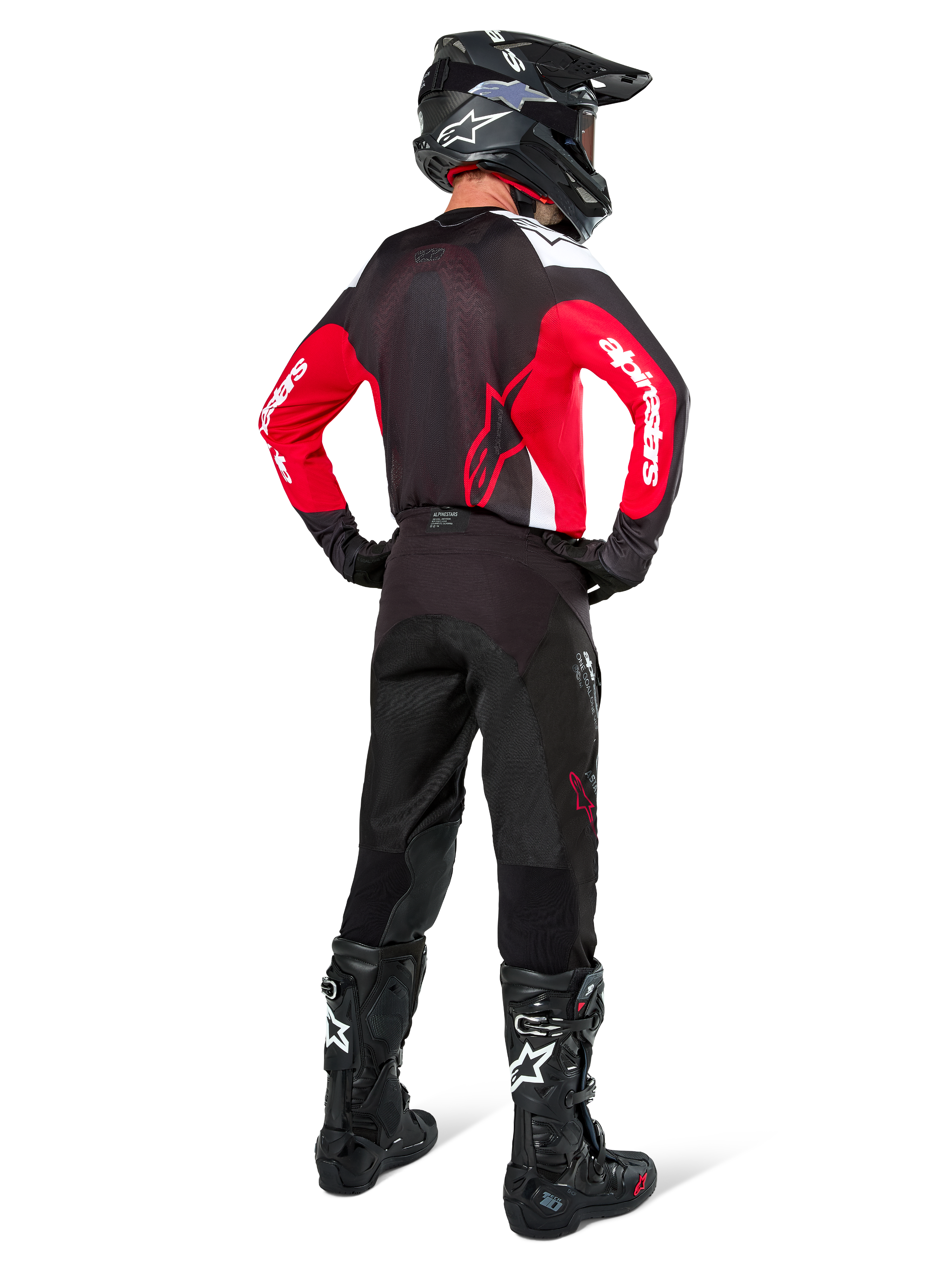 Motocrossförare sedd bakifrån bärande Alpinestars Pro-Dura-byxor i Black Magnet White, kombinerat med en röd och svart tröja och svarta stövlar, koordinerat set med offroad-utrustning för endurokörning