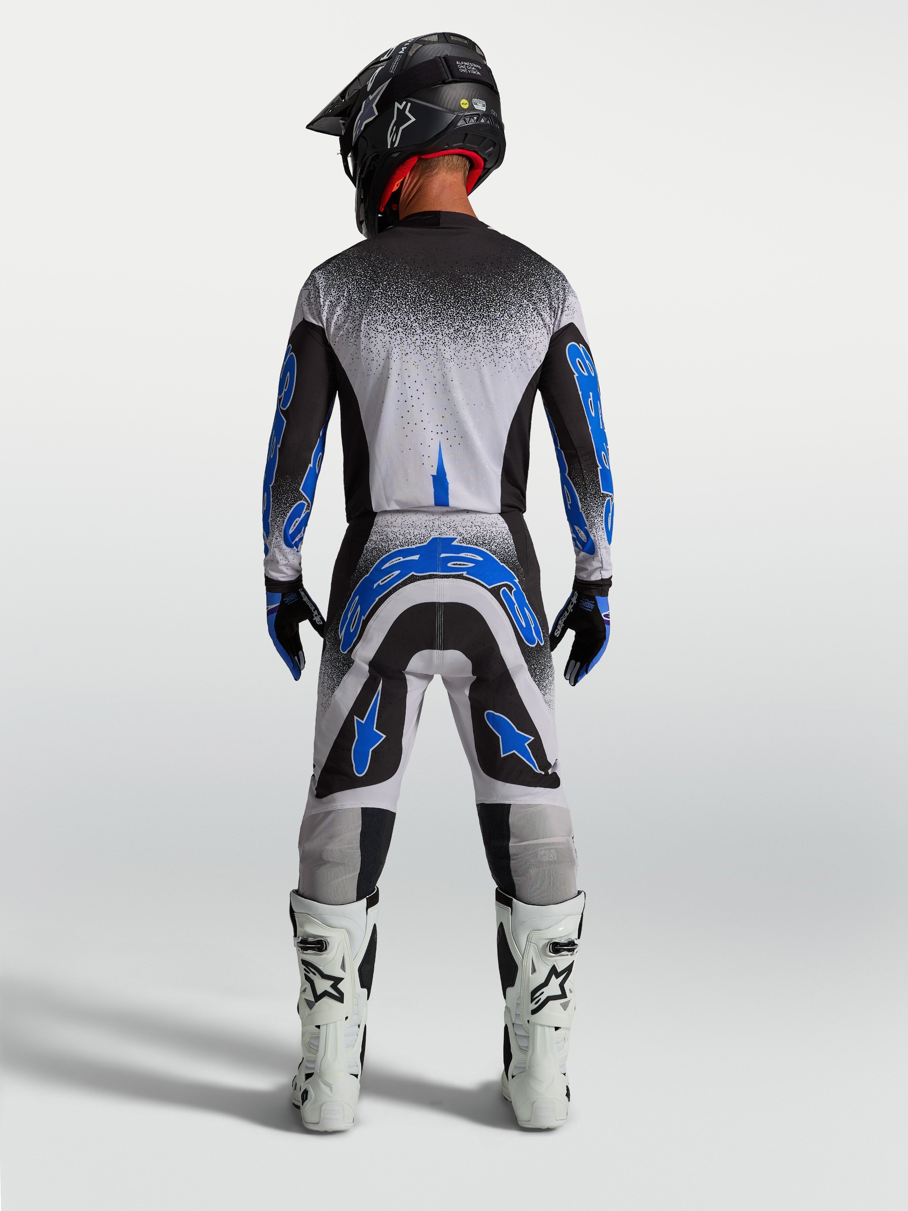 Alpinestars Supertech Hiten AFD byxor, blå och vita motocrossbyxor för herrar, atletisk vy bakifrån med racingpassform