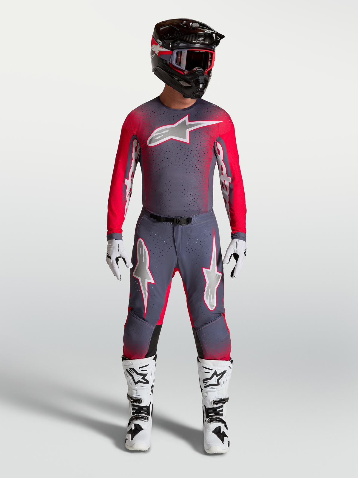 Alpinestars Supertech Hiten AFD Gear Set, professionellt motocrossutrustningsset i grått och röd fluo, komplett outfit med tröja och byxor för terrängkörning, visas på modell.