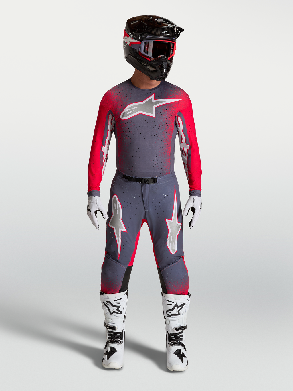 Alpinestars Supertech Hiten AFD Gear Set, professionellt motocrossutrustningsset i grått och röd fluo, komplett outfit med tröja och byxor för terrängkörning, visas på modell.