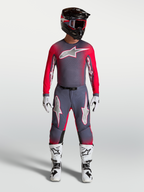 Alpinestars Supertech Hiten AFD Gear Set, professionellt motocrossutrustningsset i grått och röd fluo, komplett outfit med tröja och byxor för terrängkörning, visas på modell.
