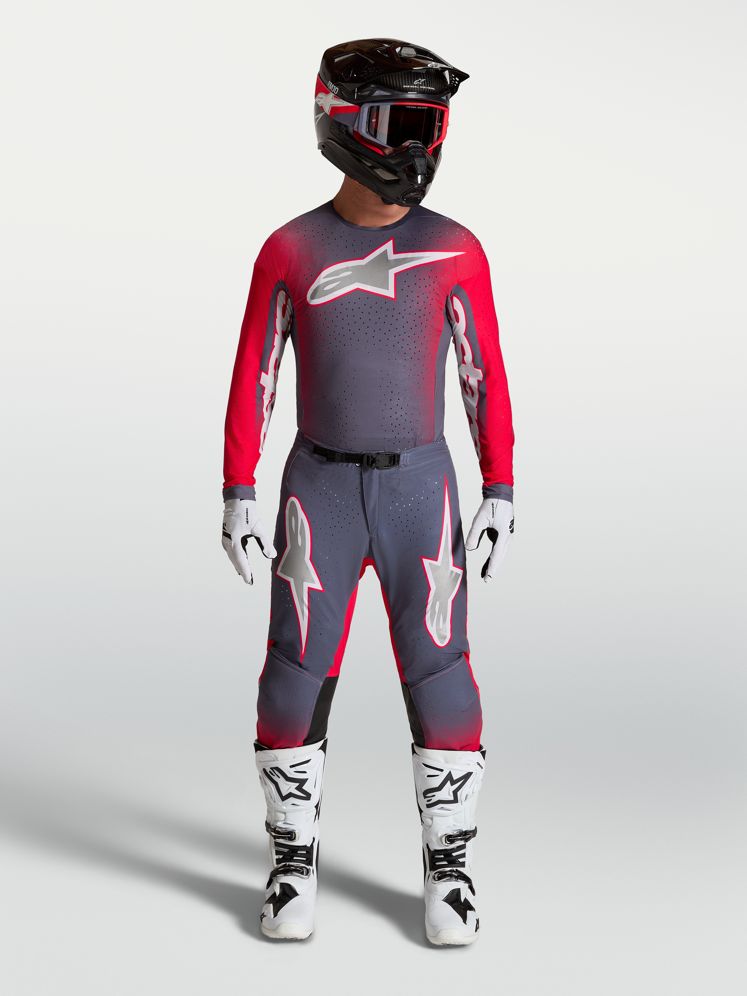 Alpinestars Supertech Hiten AFD Gear Set, professionellt motocrossutrustningsset i grått och röd fluo, komplett outfit med tröja och byxor för terrängkörning, visas på modell.