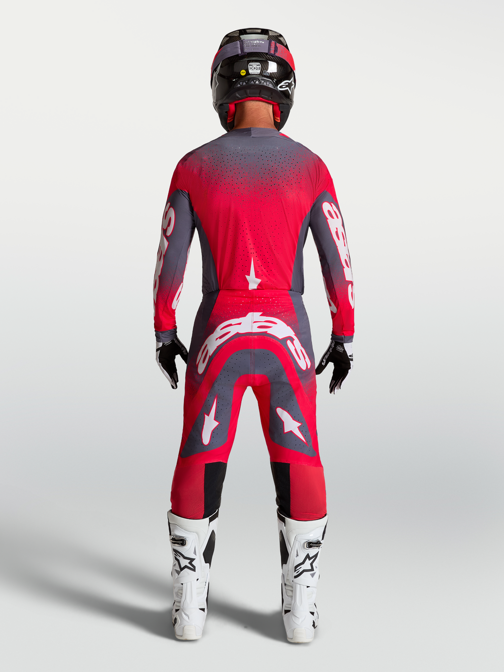 Alpinestars Supertech Hiten AFD gear set och byxor, röd fluo och grå, motocrossutrustning sedd bakifrån på modell.