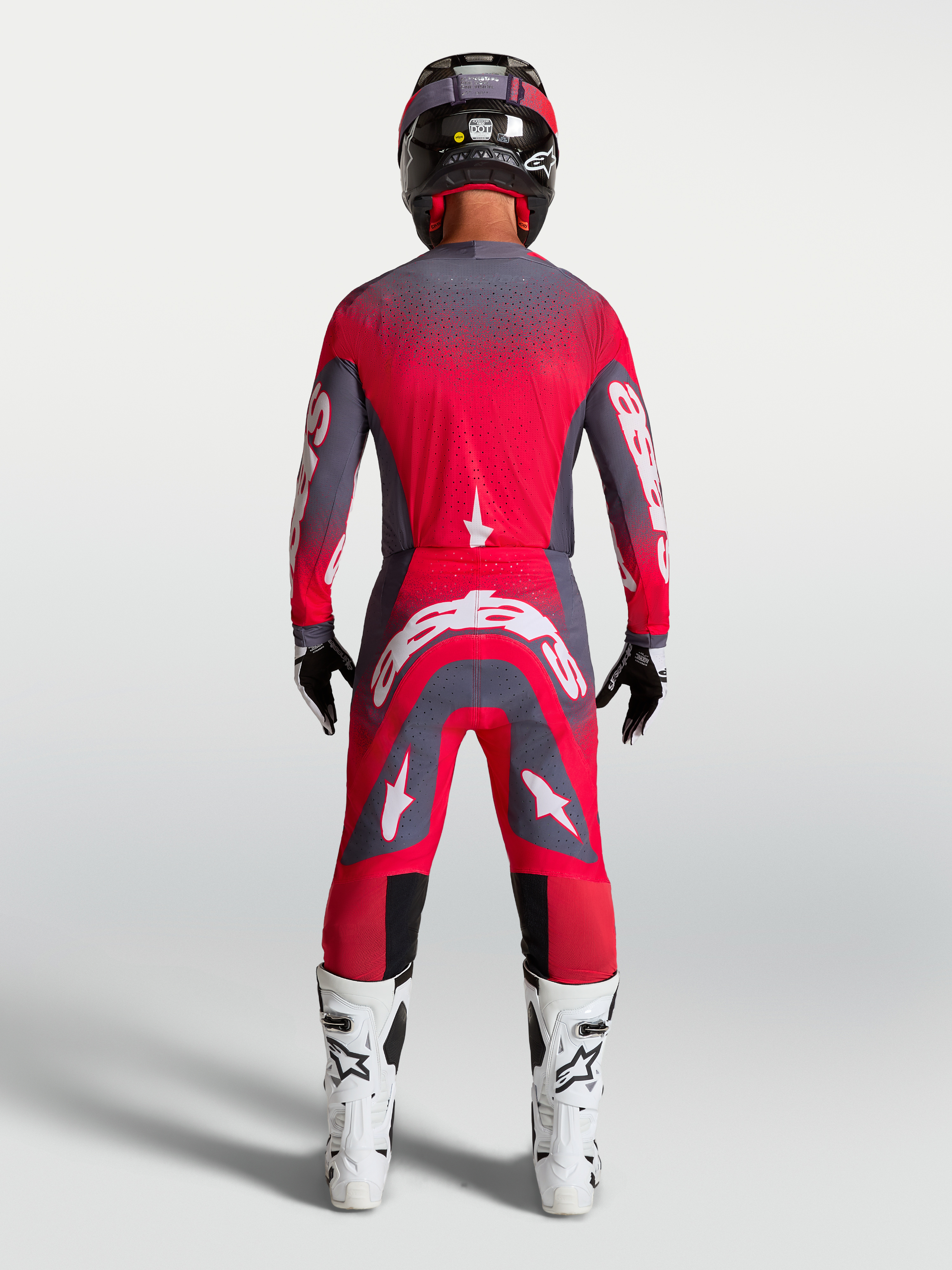 Alpinestars Supertech Hiten AFD gear set och byxor, röd fluo och grå, motocrossutrustning sedd bakifrån på modell.