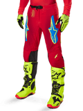 Alpinestars 2025 Supertech Maker Pants, Motocross Racing Pants, Bright Red with blue and yellow star logos, black knee panels, perforated ventilation, coordinated with neon yellow boots and gloves