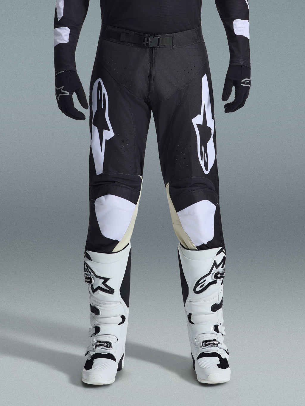 Alpinestars 2026 Racer Air Riway-byxor, motocrossbyxor, svarta och vita, med framträdande vita Alpinestars-logotyper på låren och knäpanelerna, kombinerat med vita och svarta motocross-stövlar och svarta handskar, atletisk race-fit-design för terrängkörning