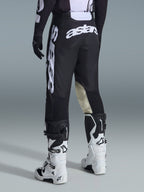 Alpinestars 2026 Racer Air Riway byxor, motocrossbyxor, svarta och vita, vy bakifrån med stor vit Astars-logotyp på sätet och benen, beige läderpaneler på knänas insida, bärs med vita och svarta Tech 7-stövlar, premium racingutrustning för terrängkörning