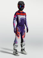 Alpinestars Supertech Dyna byxor, lila och rosa fluo motocrossbyxor för herr med matchande tröja och vita stövlar.