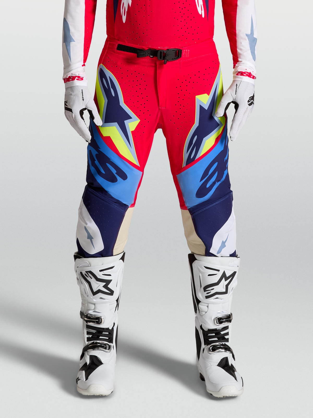Alpinestars Supertech Dyna Pants, Motocross Racing Gear for Men, Fire Red and Navy Blue with White and Yellow accents, Featuring goat leather knee panels and magnetic buckle closure.
