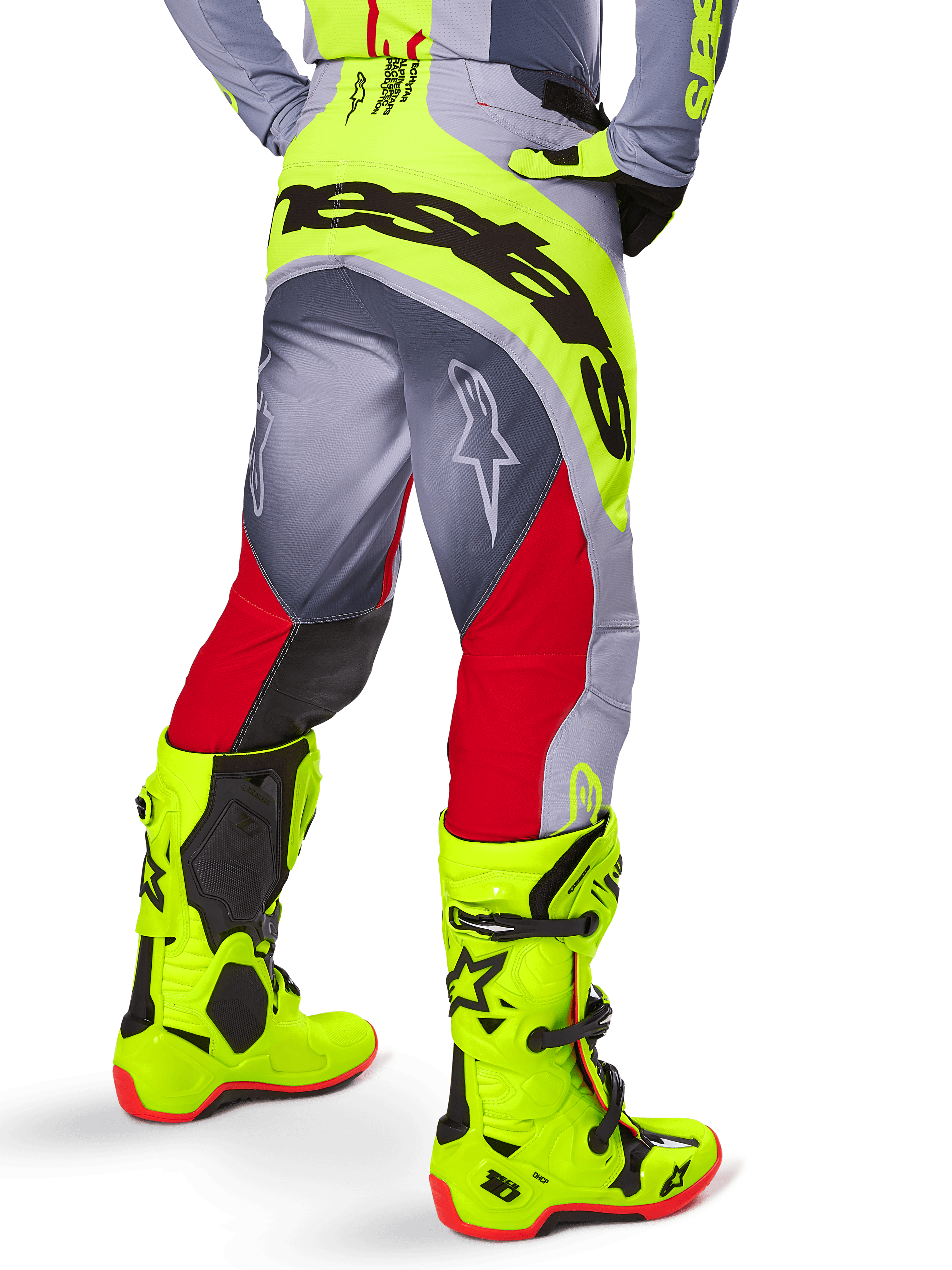 Alpinestars 2025 Techstar Melt byxor, motocrossbyxor, klarröda och grå med fluorescerande gult, vy bakifrån som visar svart Alpinestars-logotyp över sätet, matchade med neongula stövlar, designade för terrängprestanda