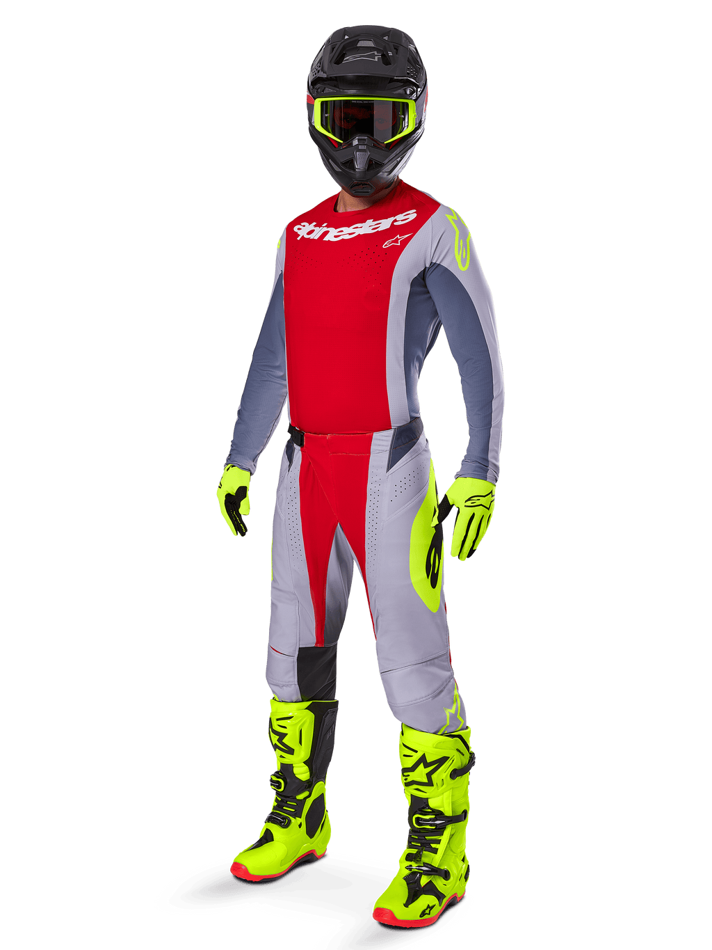 Motocrossförare i komplett racingutrustning, röd och grå tröja med Alpinestars-logotyp, 2025 Techstar Melt-byxor i klarrött och grått med neongula detaljer, klargula stövlar och handskar, svart hjälm med neongula goggles, koordinerad outfit för terrängprestanda.