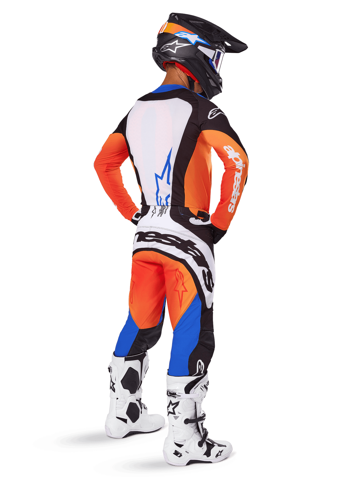 Motocrossförare sedd bakifrån klädd i Alpinestars 2025 Techstar Melt-utrustningsset, orange och blå tröja med vit ryggpanel och matchande byxor, med stor vit logotyp, svart motocrosshjälm och vita racingstövlar.