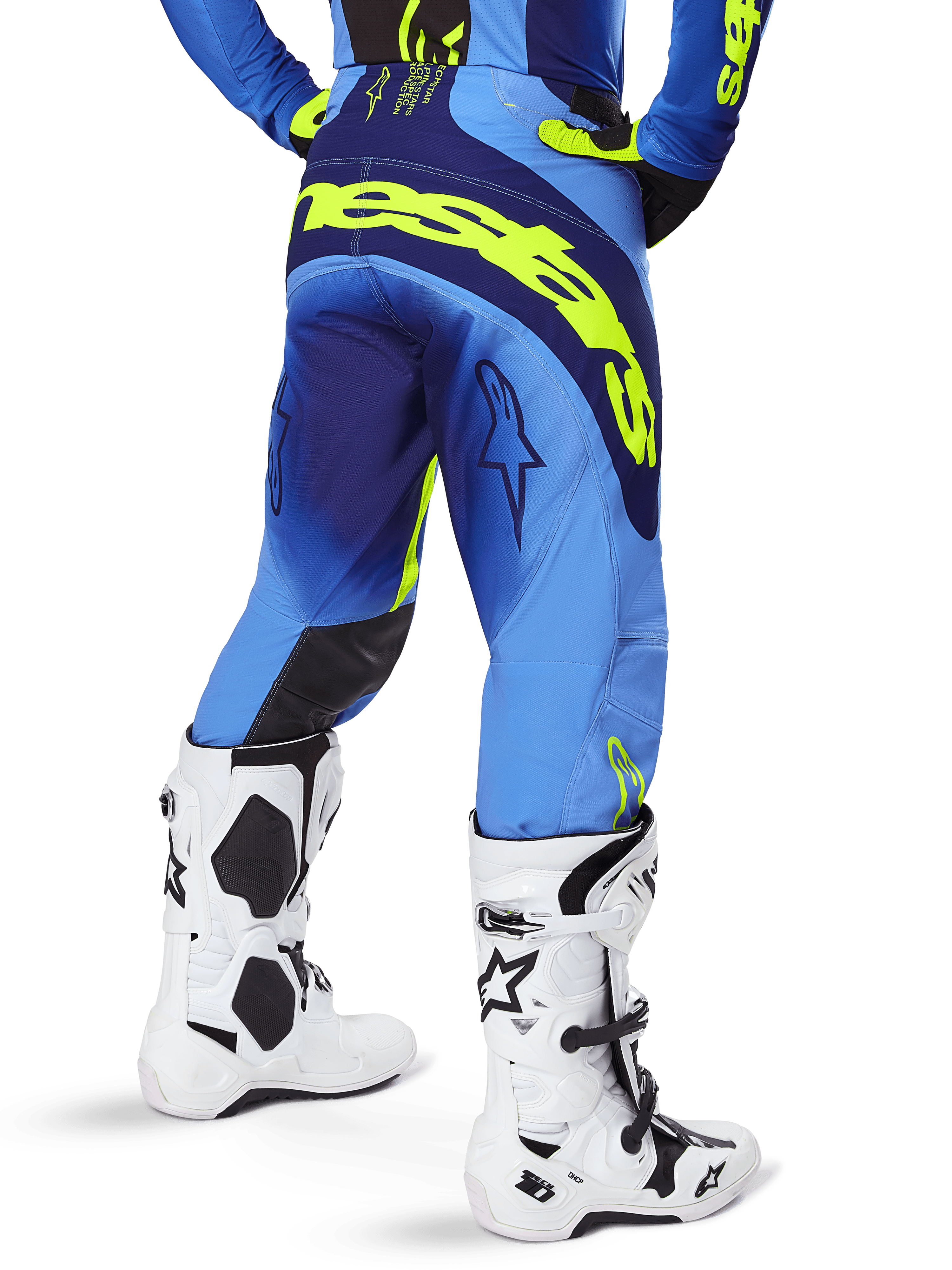 Alpinestars 2025 Techstar Melt byxor, motocrossbyxor, blå och neon-gula, vy bakifrån som visar stor gul logotyp på sätet och låren, bärs med vita motocross-stövlar och matchande blå tröja, atletisk tävlingspassform för terrängkörning