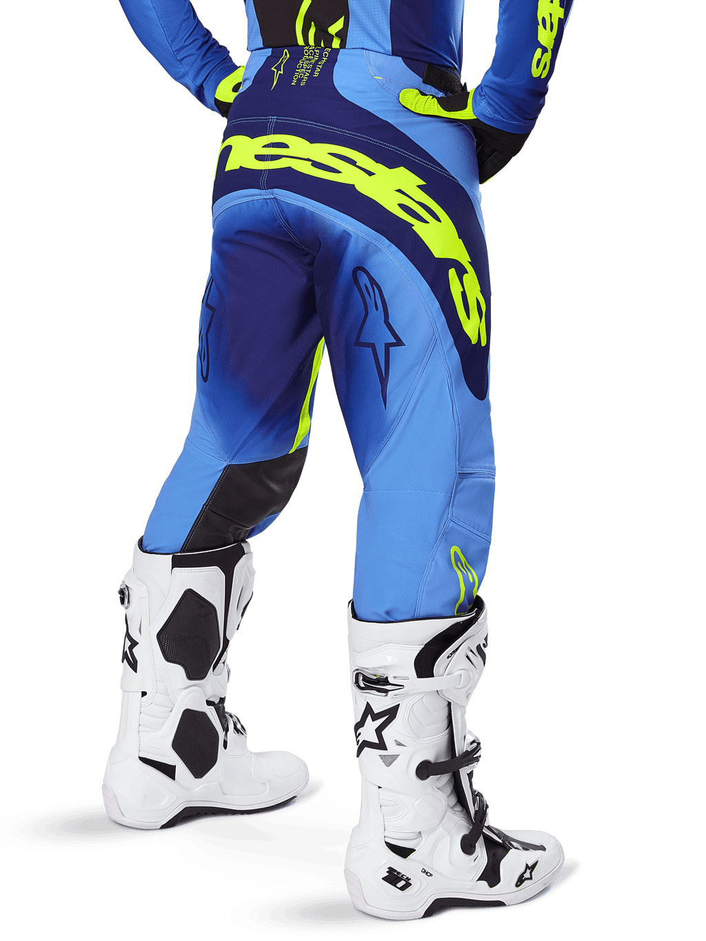 Alpinestars 2025 Techstar Melt byxor, motocrossbyxor, gul fluo och blå, vy bakifrån med stor gul logotyp över sätet och mörkblå detaljer, bärs med vita Alpinestars Tech 10-stövlar och en matchande tröja.