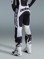 Alpinestars 2026 Racer Riway byxor, motocrossbyxor, vita och svarta, baksida som visar tydlig svart logotyp på sätet och sidorna, beige innerpaneler i getläder vid knäna, bärs med matchande vita och svarta motocross-stövlar