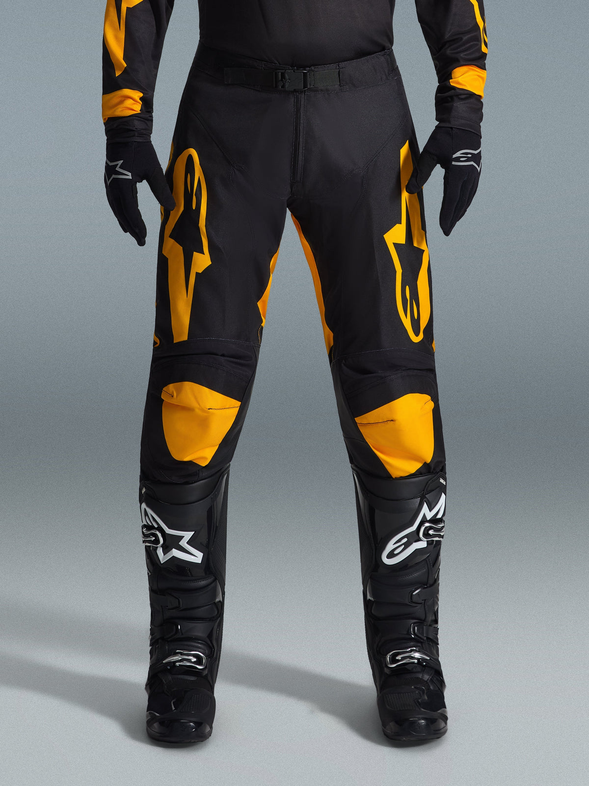 Alpinestars 2026 Racer Riway byxor, motocrossbyxor, gula och svarta, bärs med svarta motocrosshandskar och svarta stövlar med vita logotyper, med stora gula Alpinestars-logotyper på låren och gula knäpaneler, slitstark design för off-road-prestanda