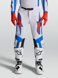 Alpinestars Supertech Vesta byxor, professionella motocrossbyxor, vita med röd och blå grafik, atletisk passform och perforerade zoner.