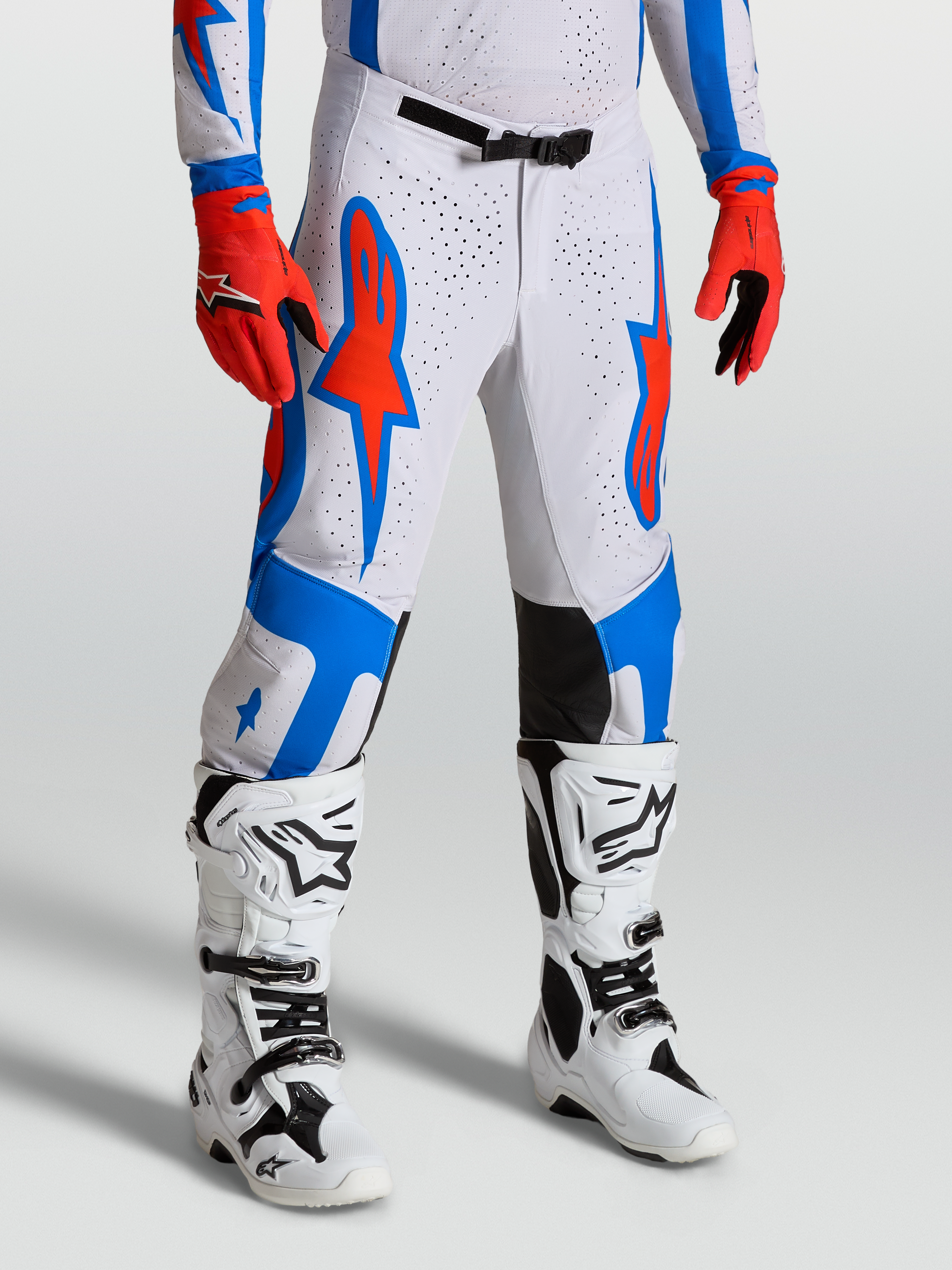 Alpinestars Supertech Vesta byxor, vita och röda motocrossbyxor med blå stjärngrafik, atletisk tävlingspassform för herr.