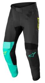 Alpinestars Supertech Blaze-byxor, motocrossbyxor, svarta, pastellgröna och neongula, med asymmetriska benpaneler med gula och turkosa stjärnlogotyper, ventilationsinsatser i mesh och justerbart midjebälte för terrängkörning