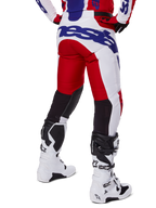 Alpinestars 2025 Racer Veil byxor, motocrossbyxor, klarröda och vita med blå logotyper, vy bakifrån som visar svarta stretchpaneler för ventilation på baksidan av benen, matchade med vita motocross-stövlar