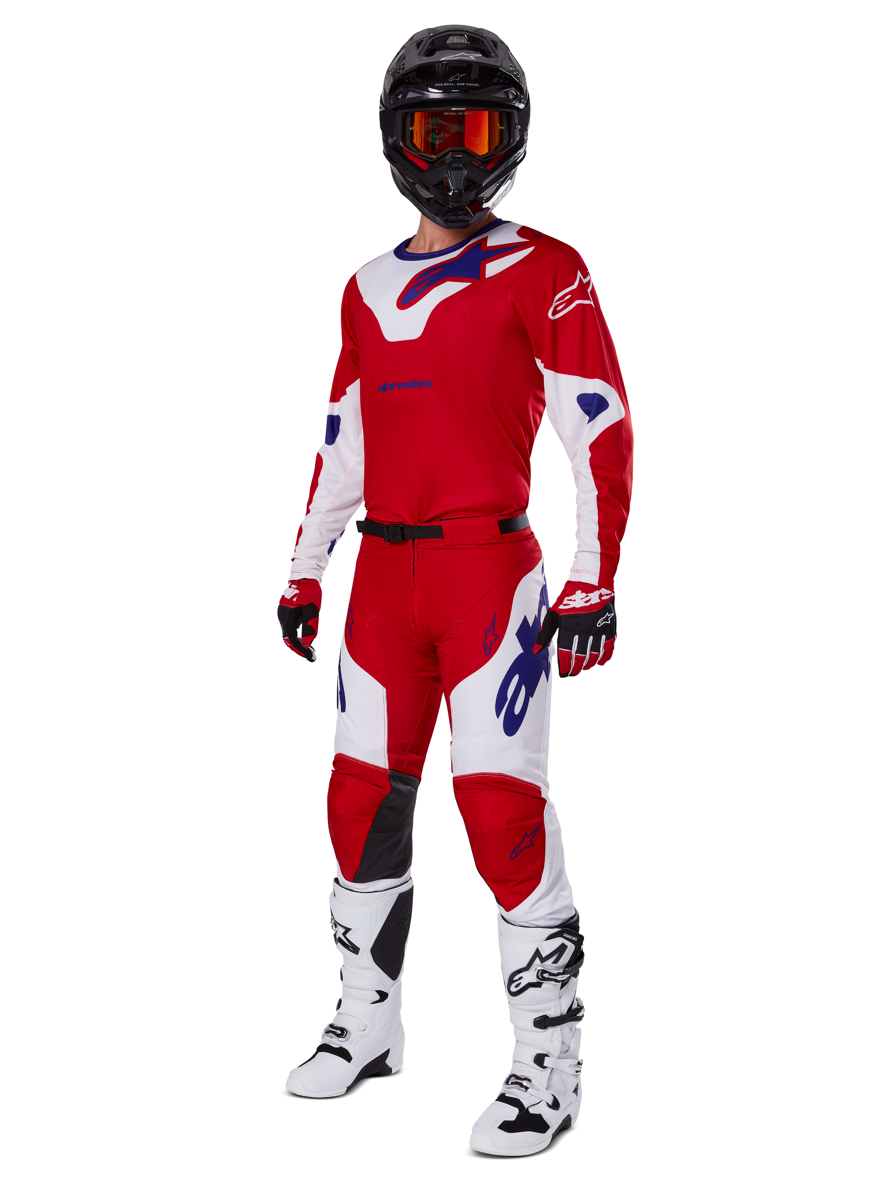 Alpinestars 2025 Racer Veil byxor, motocrossbyxor, klarröda och vita, burna som en del av en komplett racingutrustning inklusive en matchande röd och vit tröja, svart hjälm med orange goggles, vita stövlar och röda handskar, med tydliga blå Alpinestars-logotyper.