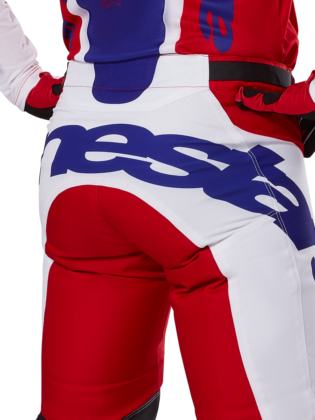 Alpinestars 2025 Racer Veil byxor, motocrossbyxor, klarröda och vita med blå logotyper, detaljbild bakifrån på sätespartiet med en stor Alpinestars-logotyp, bärs som en del av en matchande racingoutfit för terrängkörning