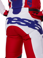 Alpinestars 2025 Racer Veil byxor, motocrossbyxor, klarröda och vita med blå logotyper, detaljbild bakifrån på sätespartiet med en stor Alpinestars-logotyp, bärs som en del av en matchande racingoutfit för terrängkörning