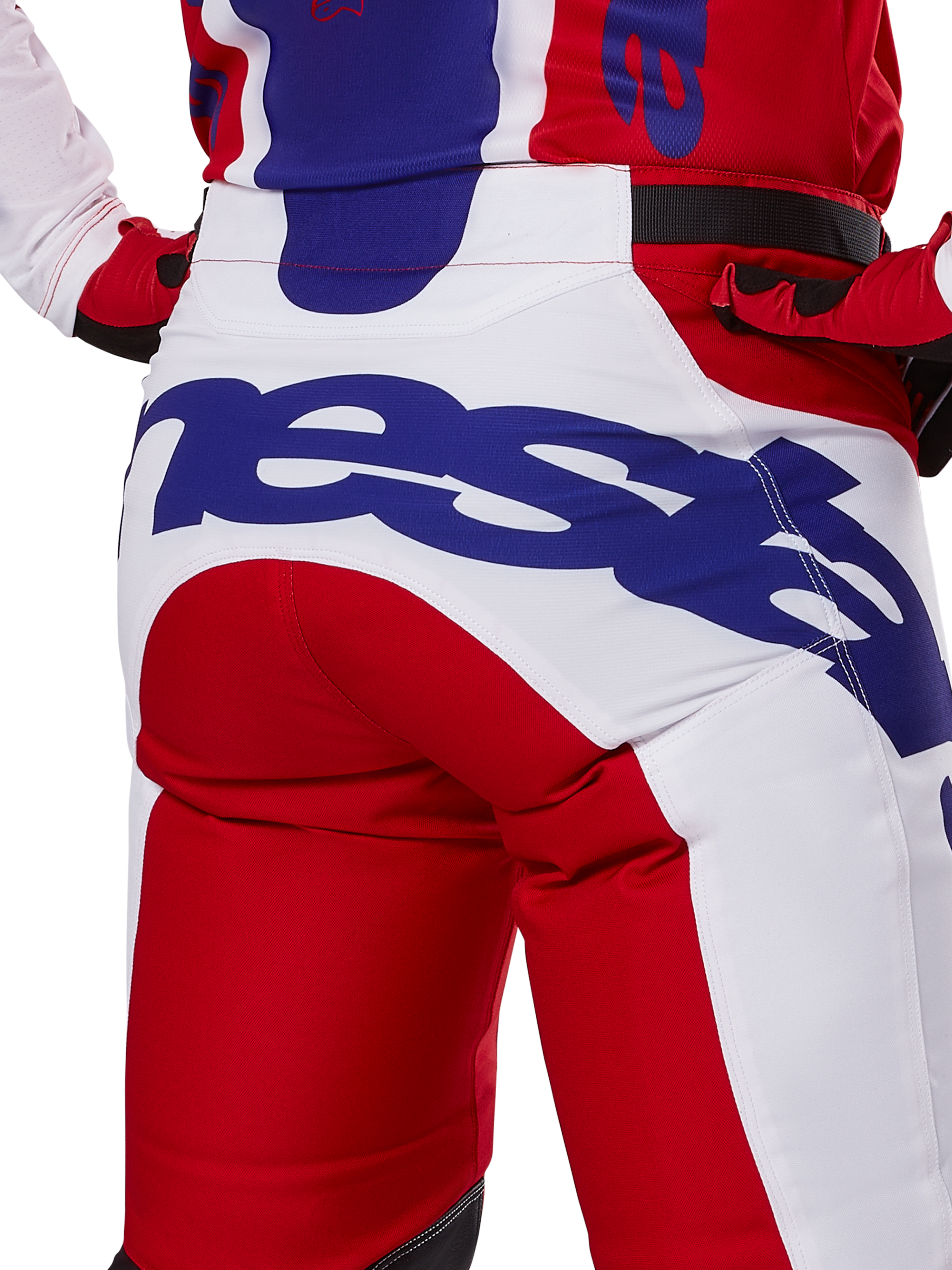 Alpinestars 2025 Racer Veil byxor, motocrossbyxor, klarröda och vita med blå logotyper, detaljbild bakifrån på sätespartiet med en stor Alpinestars-logotyp, bärs som en del av en matchande racingoutfit för terrängkörning