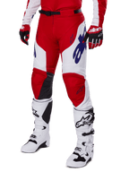 Alpinestars 2025 Racer Veil byxor, motocrossbyxor, röda och vita med blå Alpinestars-logotyper och svarta läderpaneler på knänas insida, bärs med matchande röda handskar och vita motocross-stövlar, matchande utrustningsset för terrängkörning