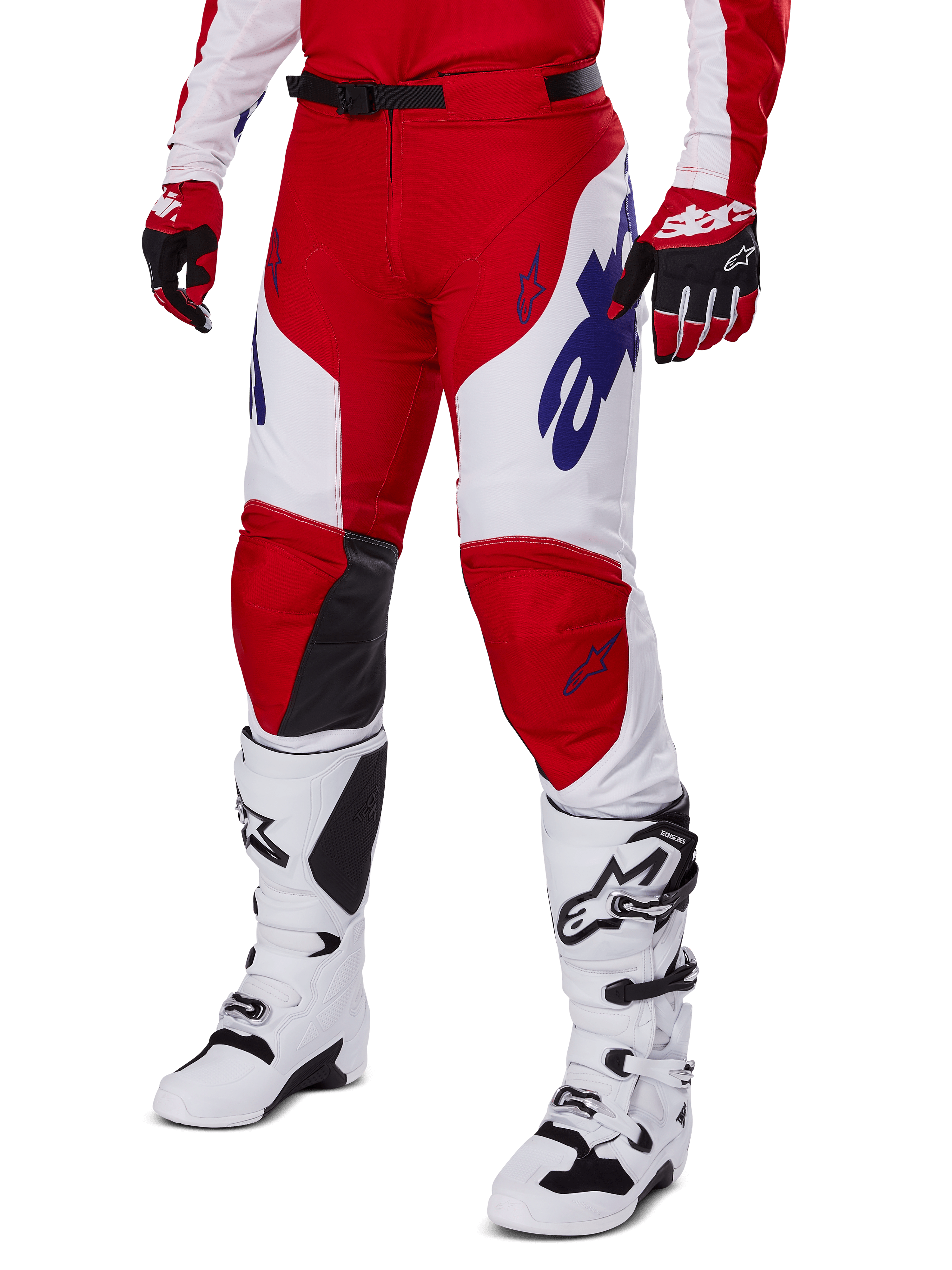 Alpinestars 2025 Racer Veil byxor, motocrossbyxor, röda och vita med blå Alpinestars-logotyper och svarta läderpaneler på knänas insida, bärs med matchande röda handskar och vita motocross-stövlar, matchande utrustningsset för terrängkörning