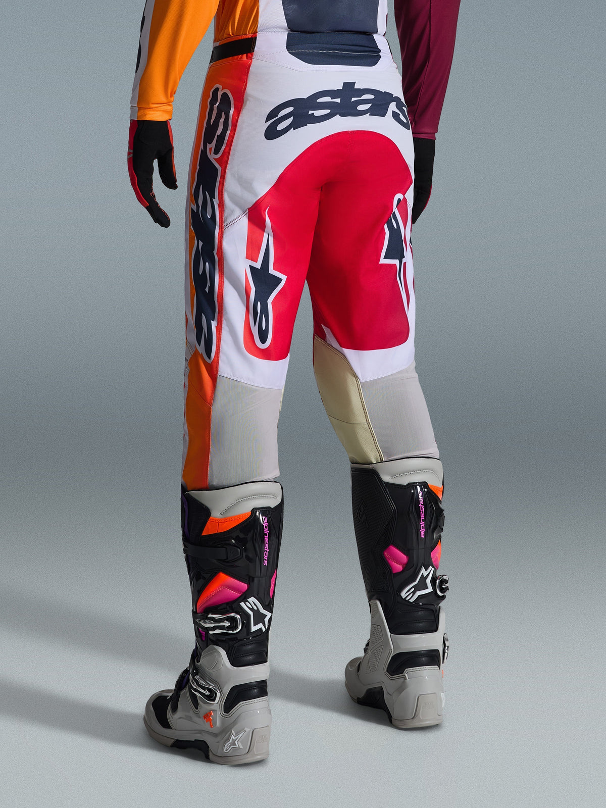 Alpinestars 2026 Racer Portl byxor, motocrossbyxor, röda, ljusgrå och mörkgrå, vy bakifrån med tydliga logotyper och varumärkesdetaljer, matchade med koordinerade motocross-stövlar och handskar, prestandautrustning för terrängkörning