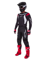 Motocrossförare i komplett Alpinestars 2025 Fluid Haul-utrustningsset, svart tröja med röda och vita detaljer, svarta byxor med vita logotyper, klarröda stövlar, röda och svarta handskar, svart hjälm med goggles, matchande off-road-prestandautrustning