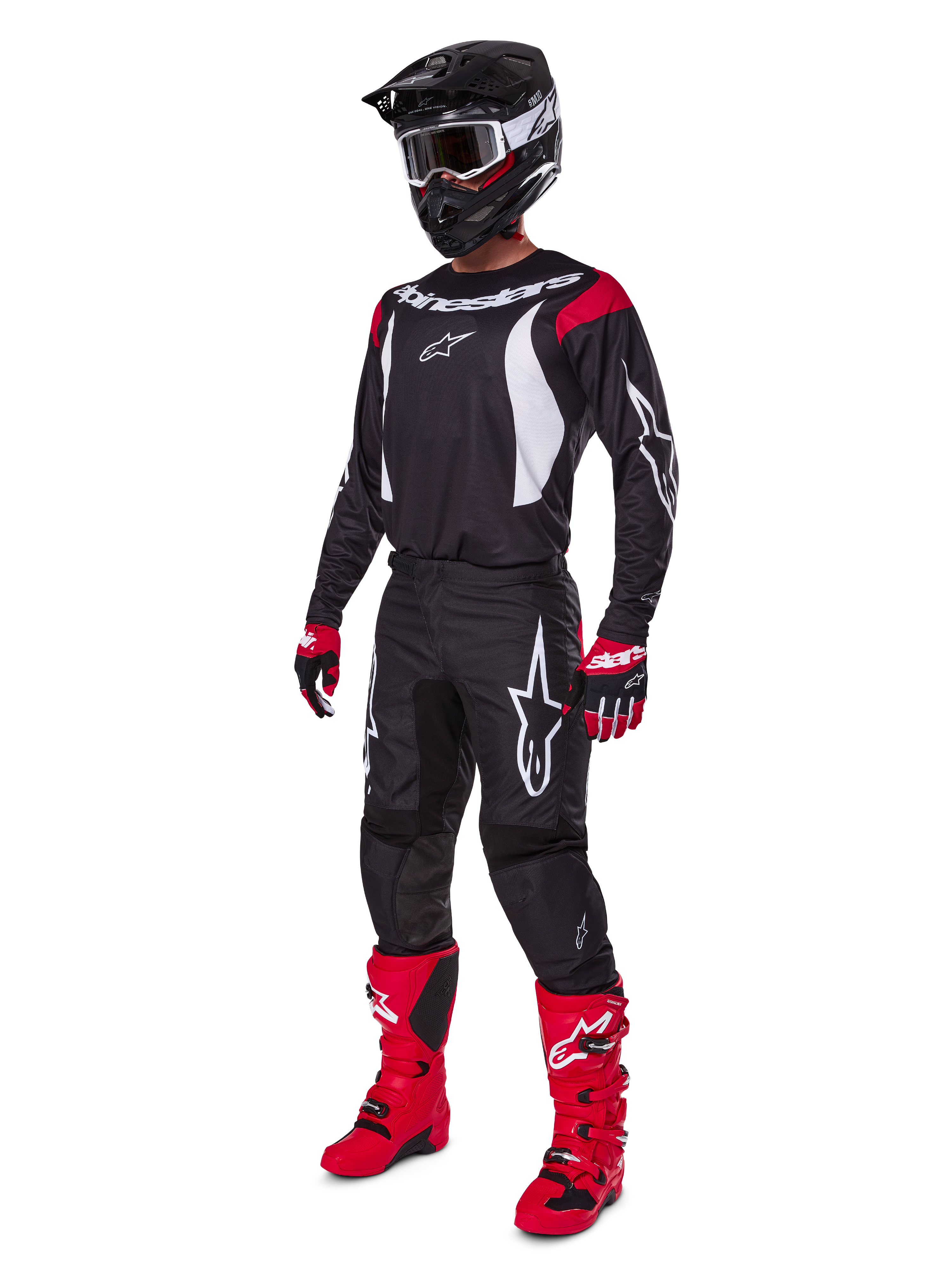 Motocrossförare i komplett Alpinestars 2025 Fluid Haul-utrustningsset, svart tröja med röda och vita detaljer, svarta byxor med vita logotyper, klarröda stövlar, röda och svarta handskar, svart hjälm med goggles, matchande off-road-prestandautrustning