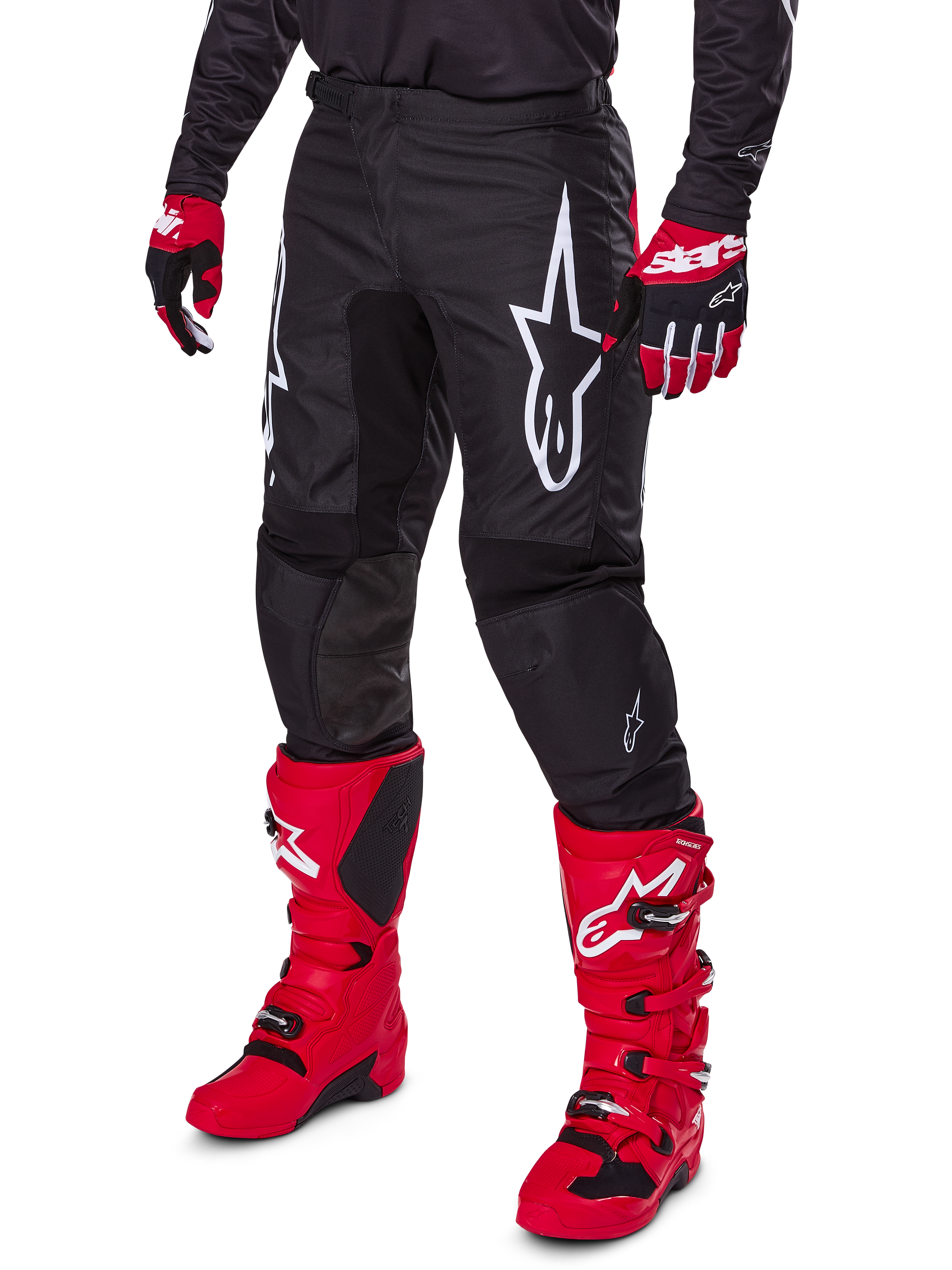 Alpinestars 2025 Fluid Haul byxor, motocrossbyxor, svarta med en stor vit Alpinestars-logotyp, bärs med klarröda stövlar och rödsvarta handskar, slitstark 600D polytygskonstruktion med ergonomisk skärning för terrängkörning