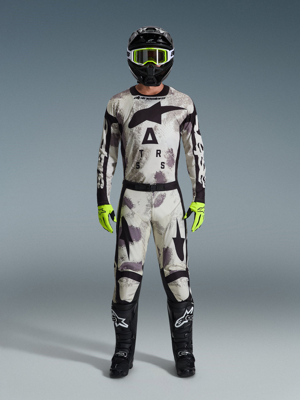 Motocrossförare i 2026 Racer Lahnd tröja och matchande byxor i Sand Camo, svart hjälm med neongula goggles, neongula handskar och svarta stövlar, komplett Alpinestars utrustningsset för offroad-racing