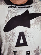 Alpinestars 2026 Racer Lahnd Jersey, Motocross Jersey, white and grey speckled pattern, close-up of chest with large black Astars logo and Alpinestars branding on the neckline, performance-oriented design for off-road riding