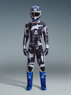 Alpinestars 2026 Racer Lahnd-utrustningsset, motocross-outfit, svart och vit med abstrakt Iron Camo-mönster, kombinerat med blå och vit hjälm och klarblå stövlar, komplett racingkit för offroad-prestanda
