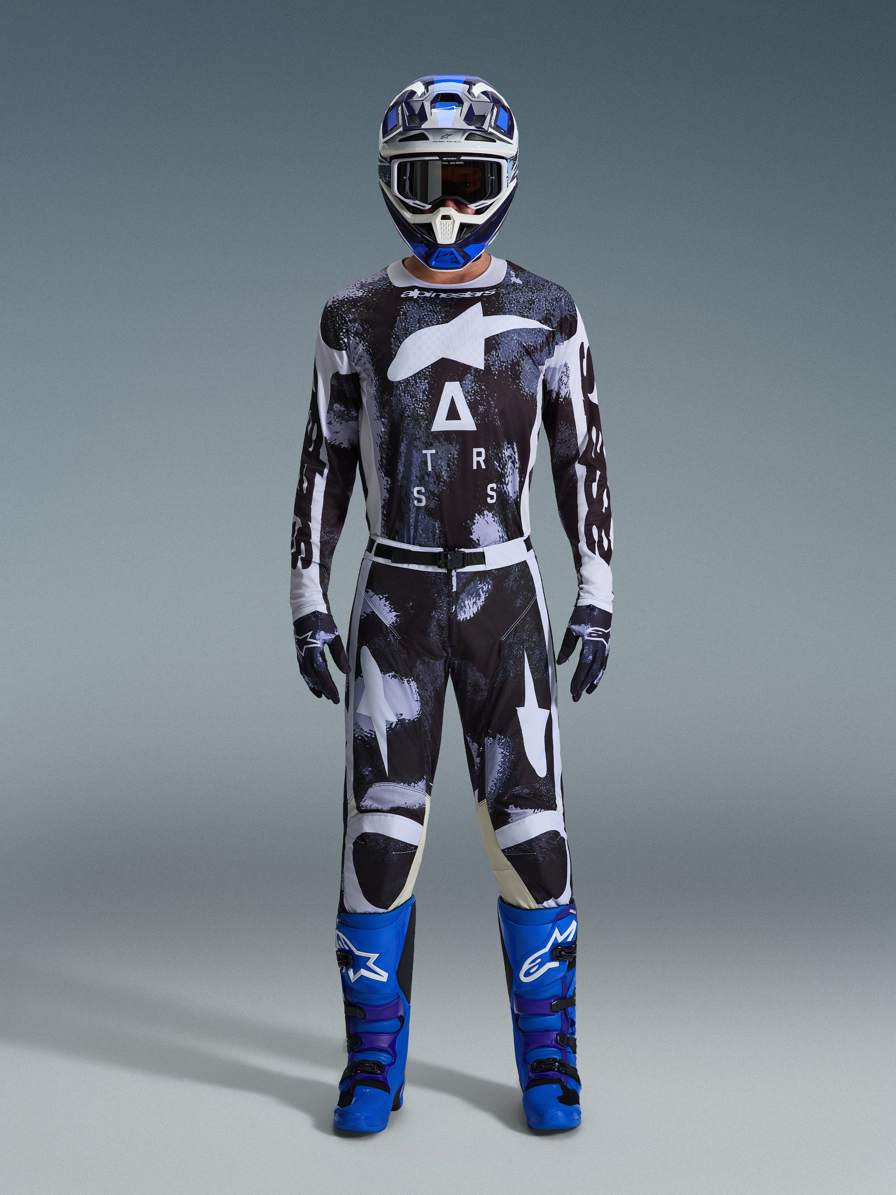 Alpinestars 2026 Racer Lahnd-utrustningsset, motocross-outfit, svart och vit med abstrakt Iron Camo-mönster, kombinerat med blå och vit hjälm och klarblå stövlar, komplett racingkit för offroad-prestanda