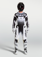 Alpinestars Techstar Swan motocross-set, tröja och byxor för herr, vit och svart med grafiskt mönster, matchande stövlar och hjälm, professionell utrustning för terrängkörning.