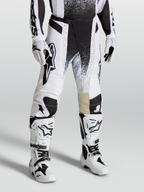 Alpinestars Techstar Swan byxor, motocrossbyxor i vitt och svart på modell med matchande stövlar, högpresterande stretch ripstop-design.