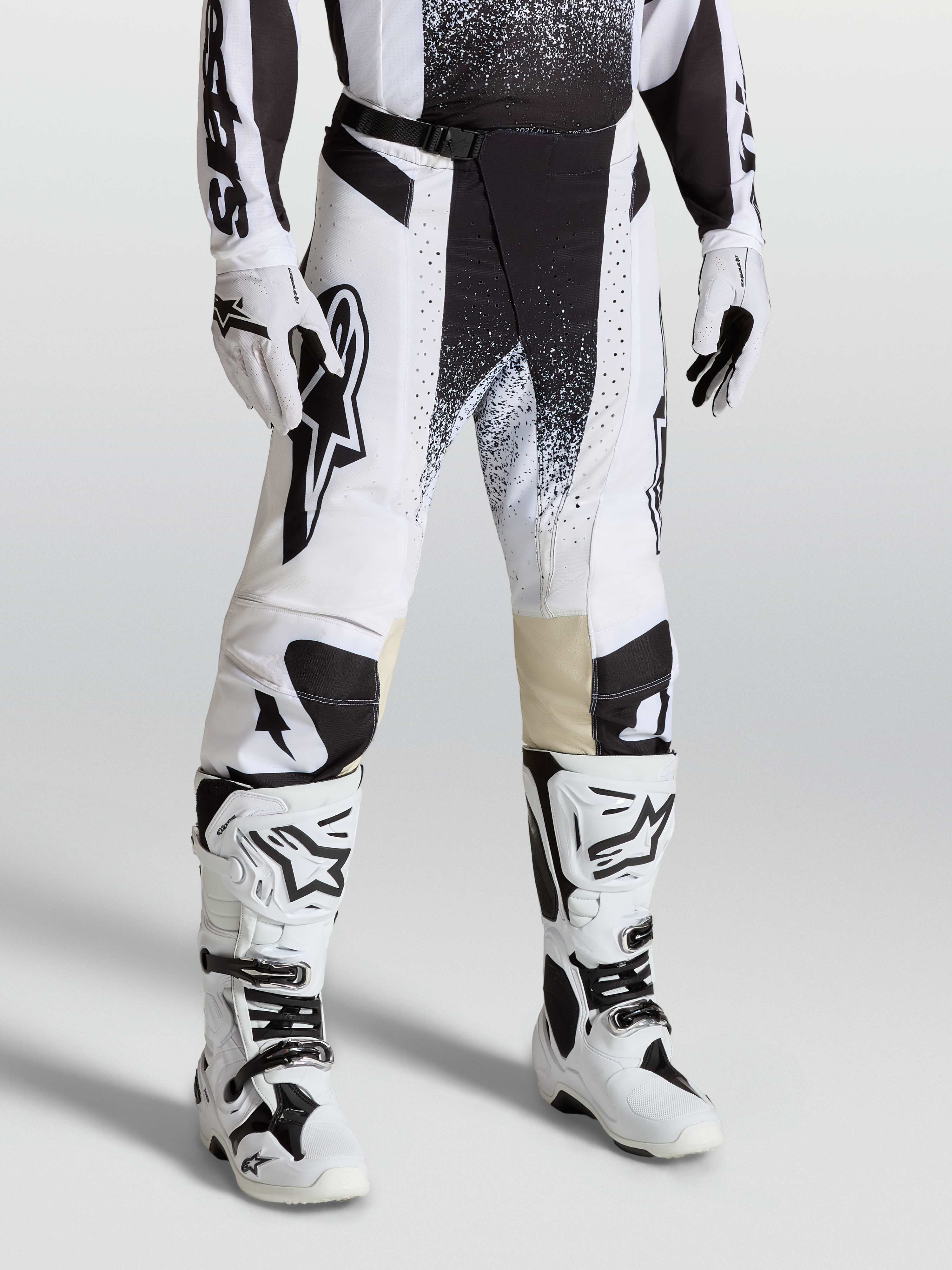 Alpinestars Techstar Swan byxor, motocrossbyxor i vitt och svart på modell med matchande stövlar, högpresterande stretch ripstop-design.