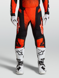 Alpinestars 2027 Techstar Swan motocrossbyxor i rött och svart, matchade med vita MC-stövlar och MC-handskar.