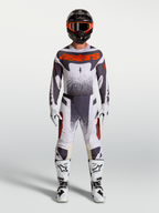 Alpinestars Techstar Swan byxor, motocrossutrustning för herr i ljuslila, mörkgrå och röd fluo med vita stövlar.