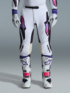 Alpinestars 2026 Supertech AFD Vista-utrustningsset, vita motocrossbyxor med lila och rosa gradient-logotyper, vita stövlar med livfulla rosa detaljer, vita och svarta handskar, professionell motocross-racingoutfit