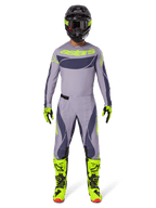 Motocross rider wearing complete racing gear, Alpinestars 2025 Techstar Dreem Pants in Gray and Dark Gray, matching jersey with fluorescent yellow branding, black helmet, fluorescent yellow boots and gloves, coordinated performance outfit for off-road racing