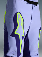 Alpinestars 2026 Supertech Scenz Pants, Motocross Pants, Purple Yellow Fluo, close-up featuring large yellow logo on the thigh, laser-cut perforations for ventilation, and magnetic waist buckle, athletic-fit off-road gear