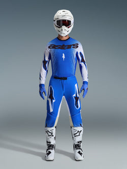 Alpinestars 2026 Supertech Scenz utrustningsset, motocrossutrustning, Ucla Blue och vit, komplett tävlingsoutfit med en blå tröja med svart 'astars'-logotyp, matchande byxor med stjärngrafik, vit hjälm med mörka goggles, blå handskar och vita stövlar med svarta detaljer