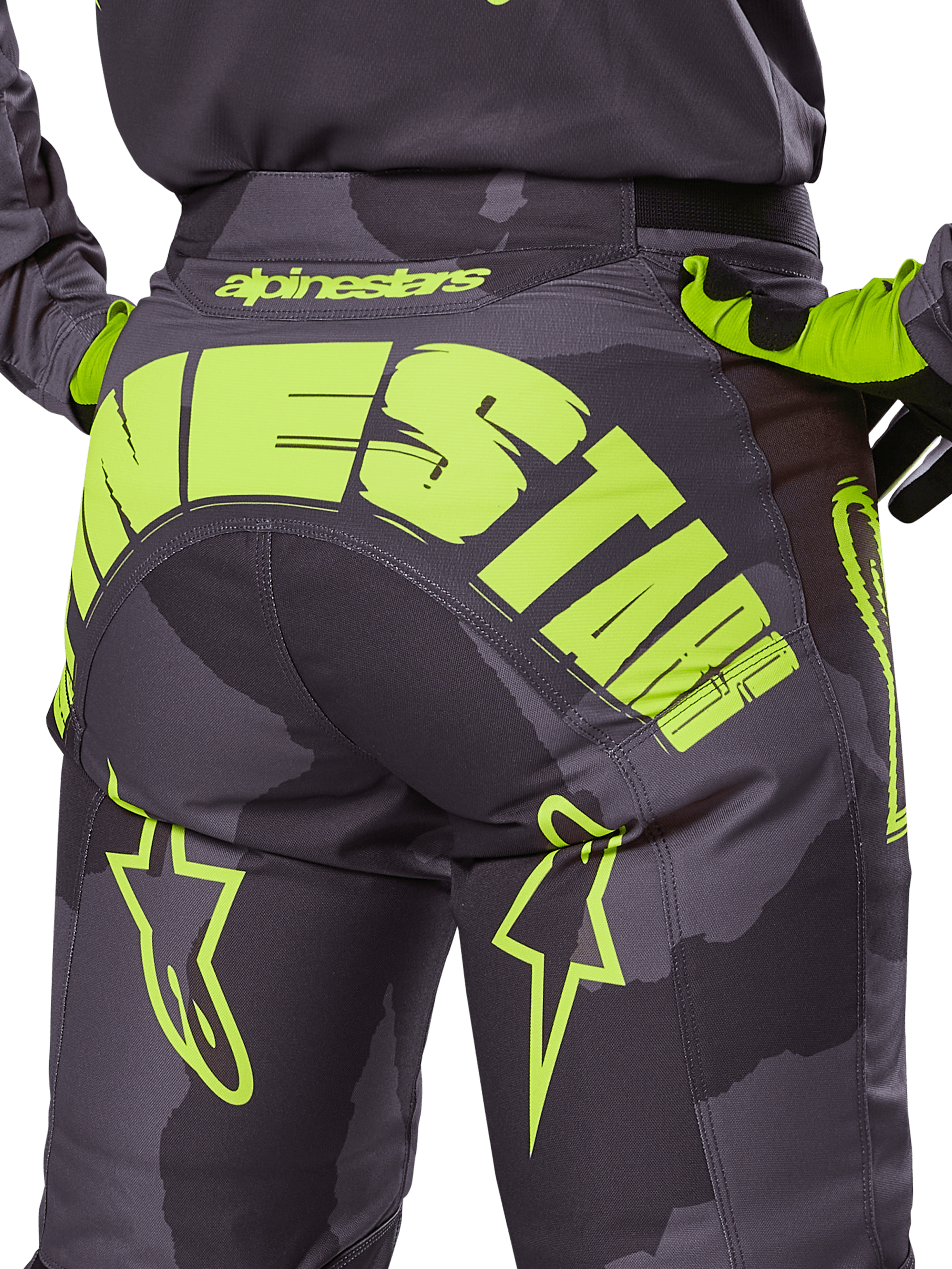 Alpinestars 2025 Racer Hollow byxor, motocrossbyxor, Dark Camo och Yellow Fluo, med en stor gul Alpinestars-logotyp över baksidan, taktiskt kamouflagemönster med klargula accenter och hållbar konstruktion för terrängkörning